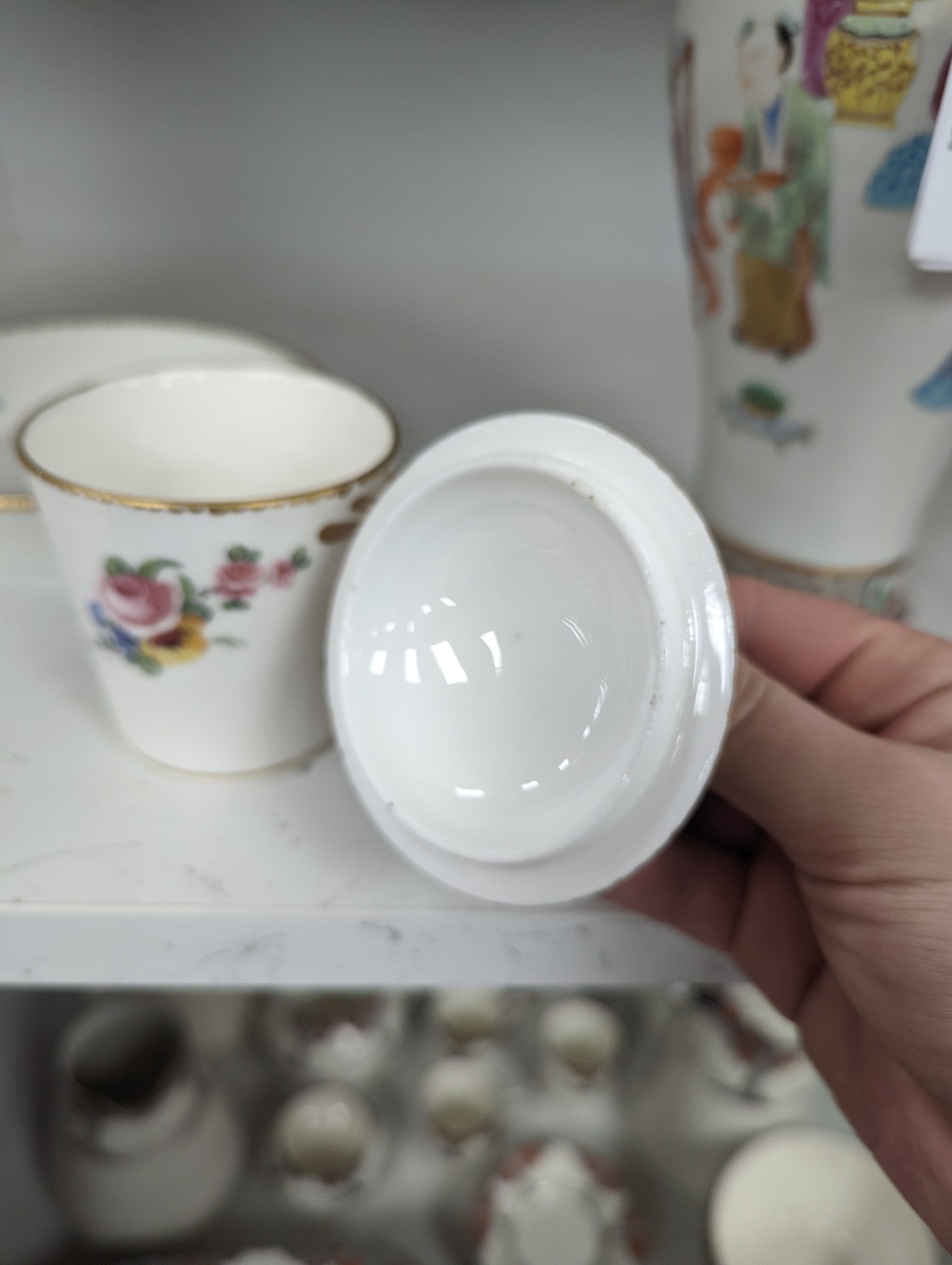 A Sevres tapering cup with entwined handle and cover and stand painted with flowers, date code for 1780, painters mark for Le Bel jnr., square incised marks, height 10.5cm